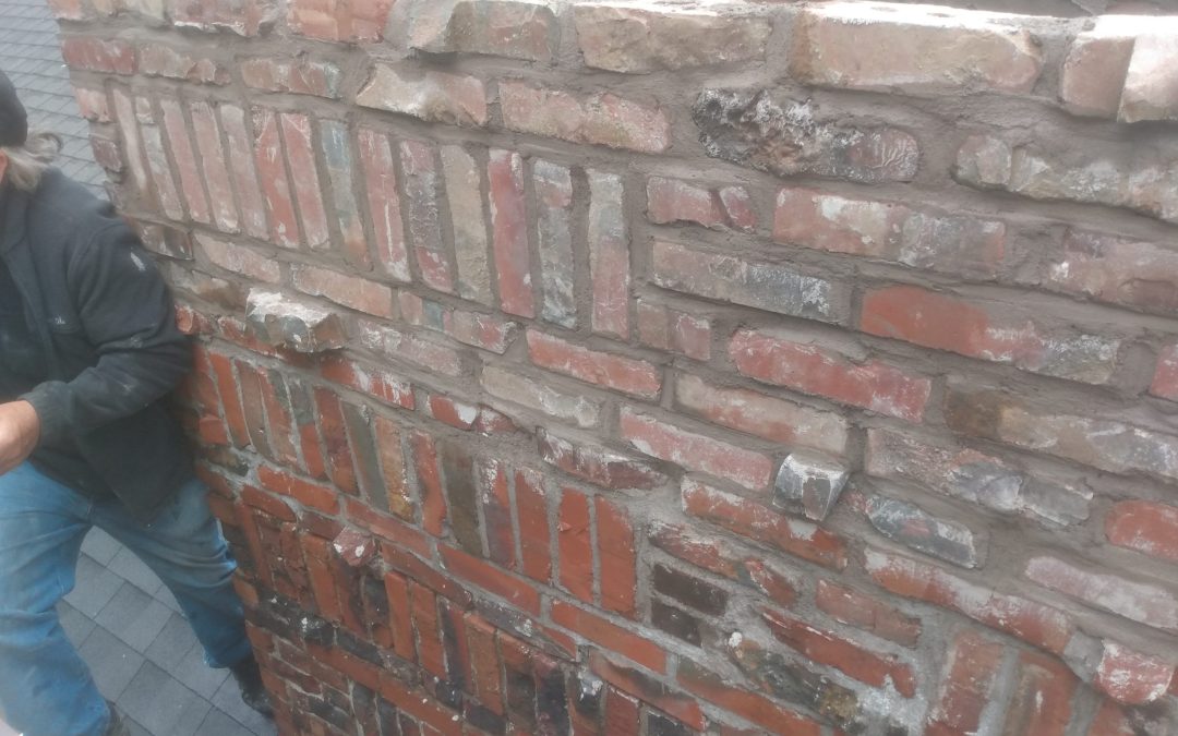 Person behind a weathered brick wall.