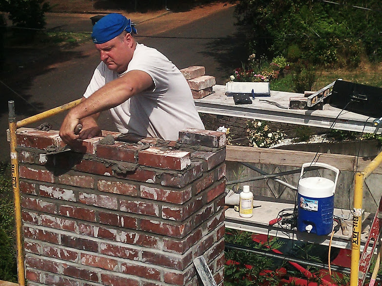 Man laying bricks on a sunny day.