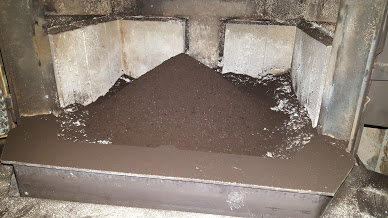 Pile of ashes in a used fireplace.