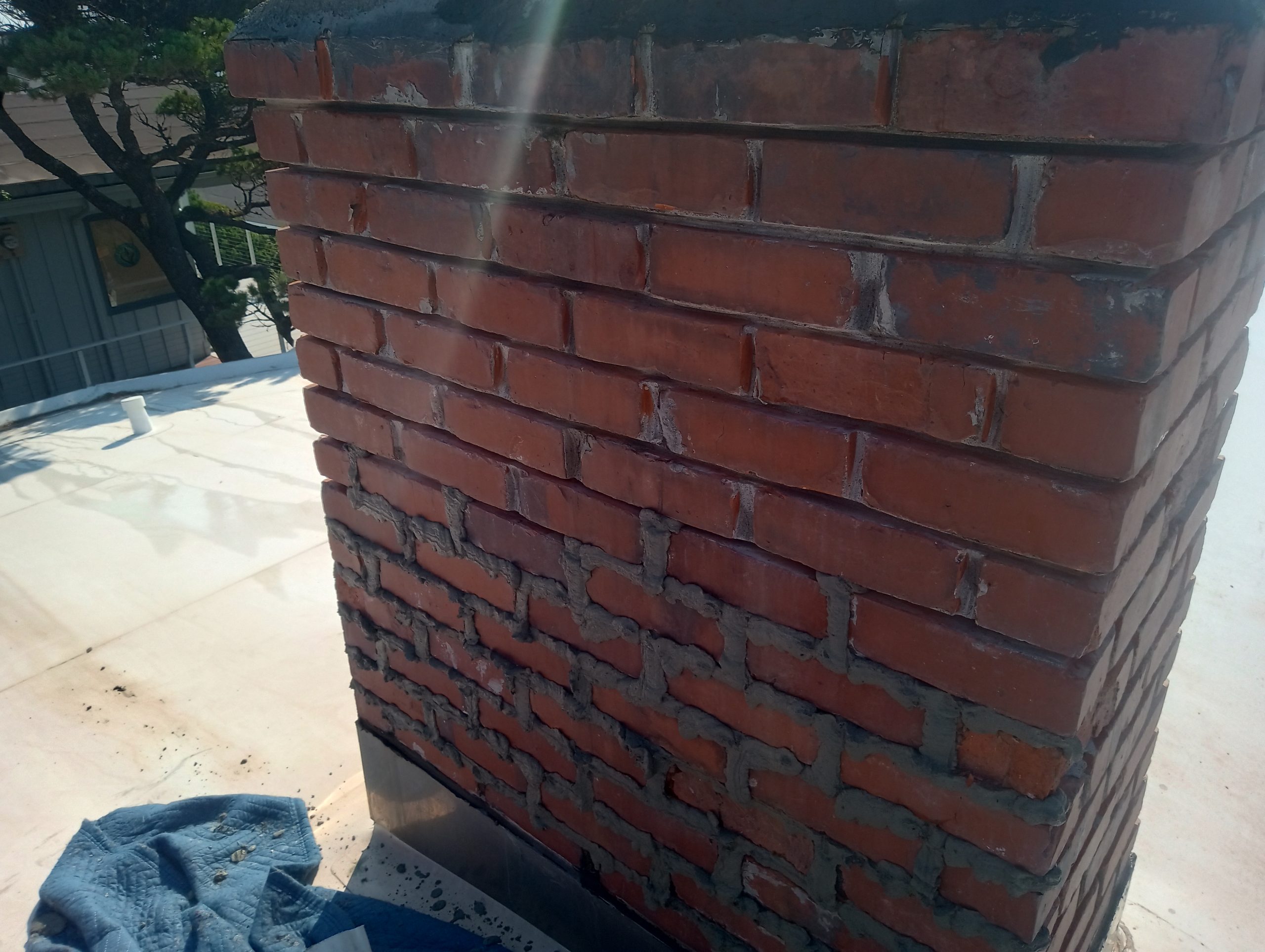 Newport, Oregon. Chimney mortar joint repair ("tuckpointing") New mortar in chimney mortar joints. Ready to be formed and tooled smooth.